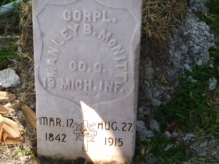 A square, flat tombstone with the name Corpl. Manley B. McNitt and the dates March 17 1842-Aug 27 1915